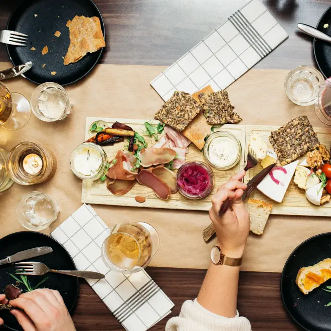 Lyst spisebord dekket med servise og tapasmat. 