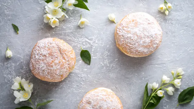 berliner donuts in powdered sugar on a gray background