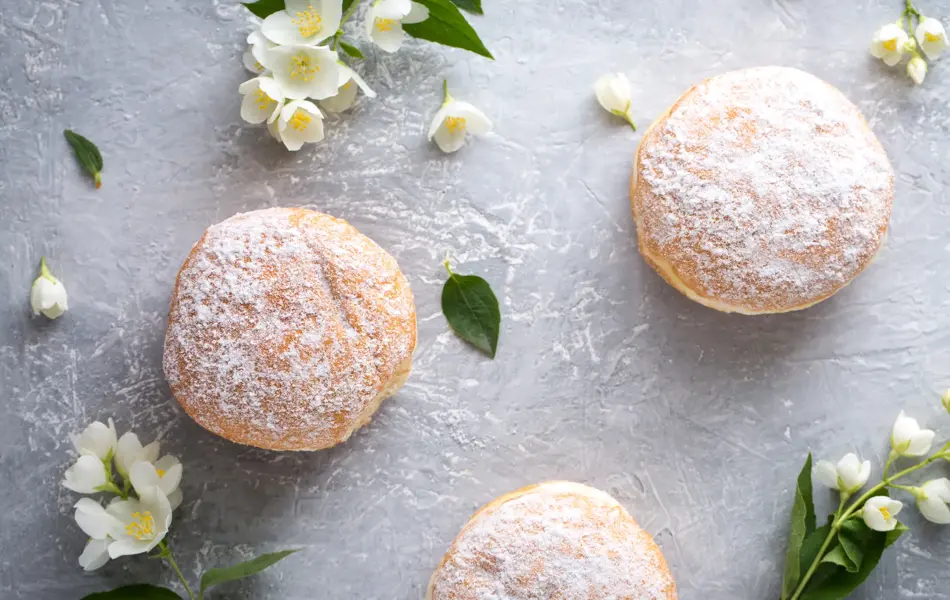 berliner donuts in powdered sugar on a gray background