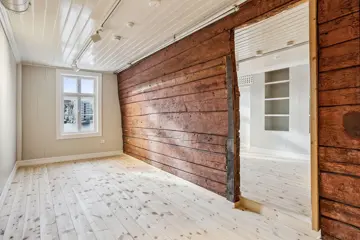 Et kontorlokale i Svensgården på Bryggen i Bergen. Historiske tømmervegger er bevart som en integrert del av lokalene og skaper en arbeidsplass med unik identitet.
