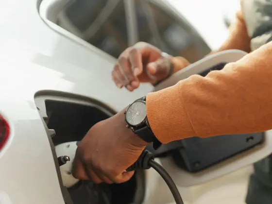 Nærbilde av ung mann som lader elektrisk bil