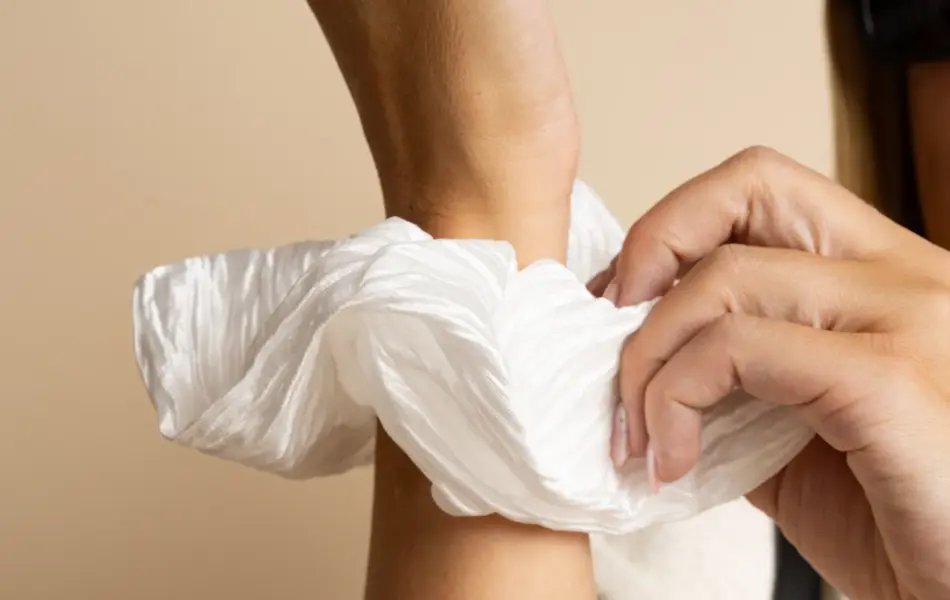 Hånd med stor hvit scrunchie.