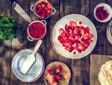 Delicious Berry Pavlova Cake with fresh strawberries, raspberries, mint leaves and whipped cream.