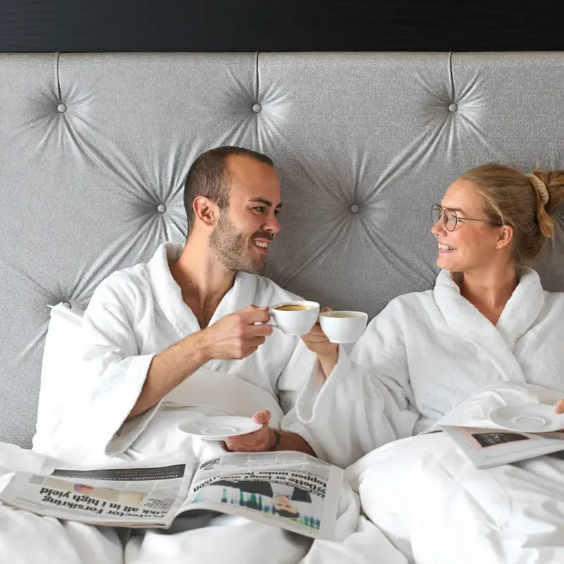 Kjærestepar, hotellseng, kaffe