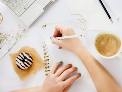 To hender som skriver i en notatbok