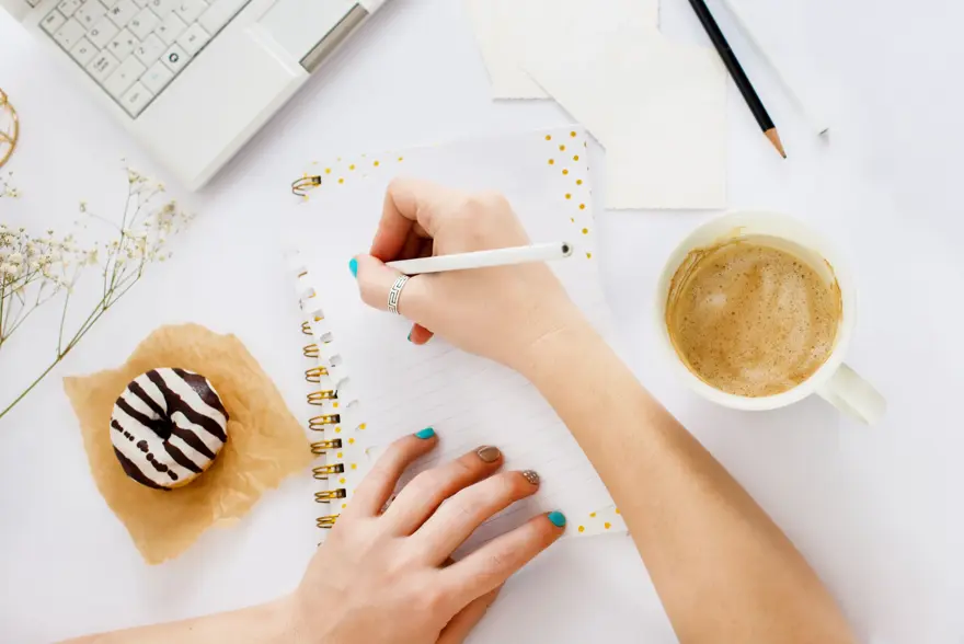 To hender som skriver i en notatbok