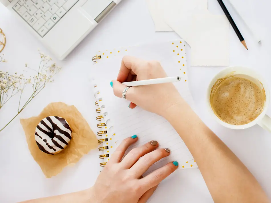 To hender som skriver i en notatbok