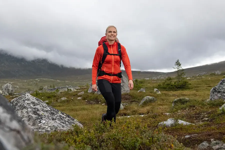 dame med rød jakke som er ute på tur i villmarken
