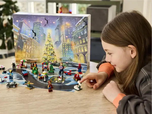 Ung jente som leker på et bord med LEGO som hun har fått i adventkalenderen sin 