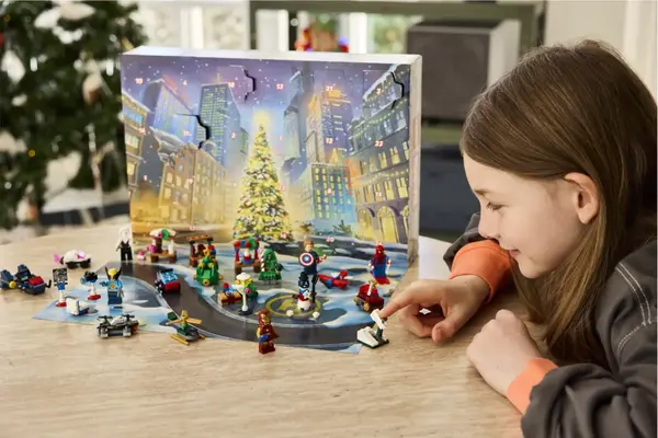 Ung jente som leker på et bord med LEGO som hun har fått i adventkalenderen sin 