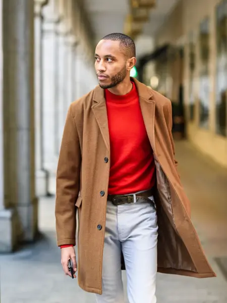 Mann med brun frakk og rød genser 