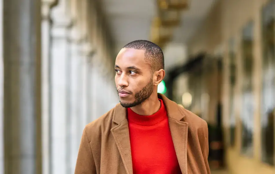 Mann med brun frakk og rød genser 