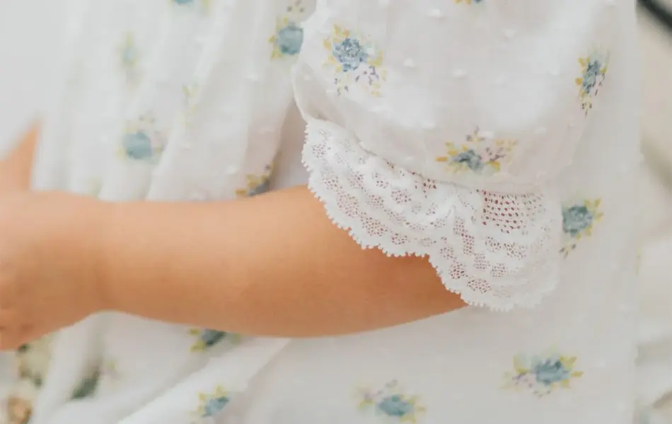 Barn med kjole med blå blomster på