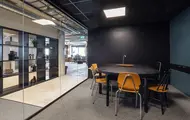 Interiør fra kontoret til The Oslo Company, møterom med mørkegrønne vegger, gammeldagse trestoler og en vegg i glass hvor man ser resten av kontoret utenfor