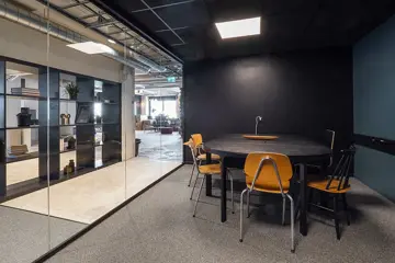 Interiør fra kontoret til The Oslo Company, møterom med mørkegrønne vegger, gammeldagse trestoler og en vegg i glass hvor man ser resten av kontoret utenfor