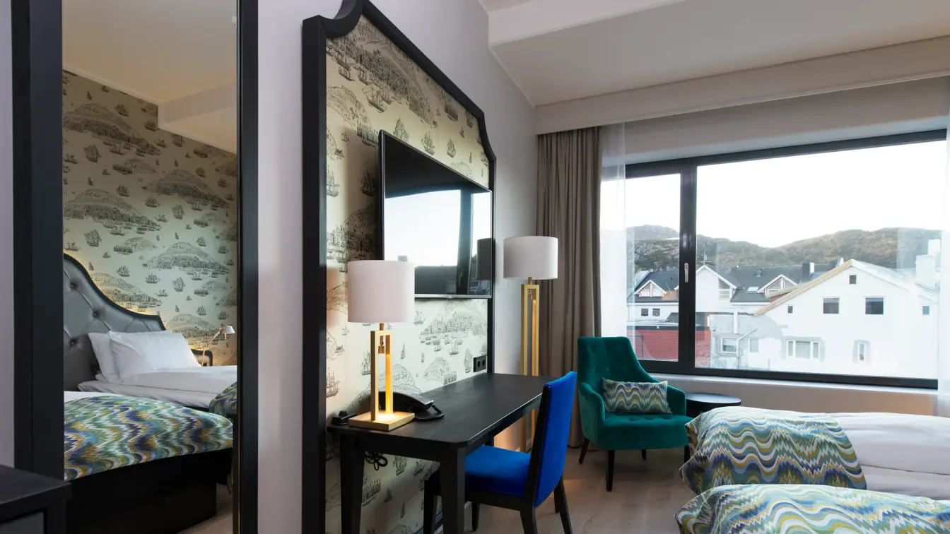 Twinseng, arbeidspult og stol på twinrom på Thon Hotel Fosnavåg med utsikt utover havet