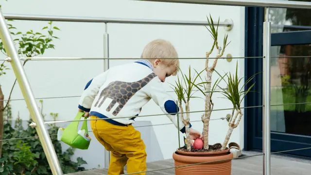 Little boy finding an Easter egg in plant pot