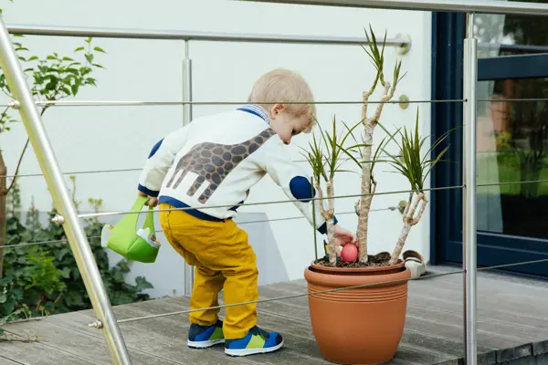Little boy finding an Easter egg in plant pot