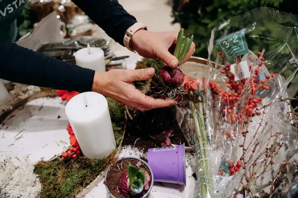 ansatt viser frem hvordan hen lager bordpynt