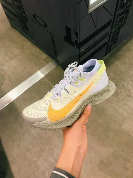 Nærbilde av en joggesko som blir holdt opp av en hånd