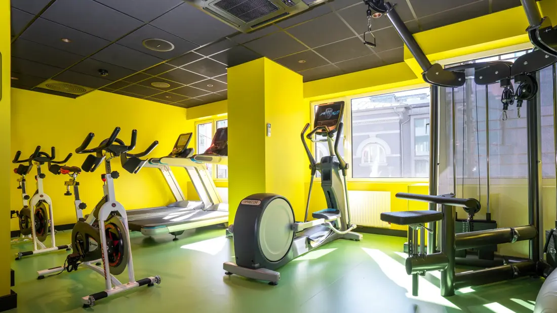 Treningssykler i gult, fargerikt treningsrom på Thon Hotel Gyldenløve i Oslo