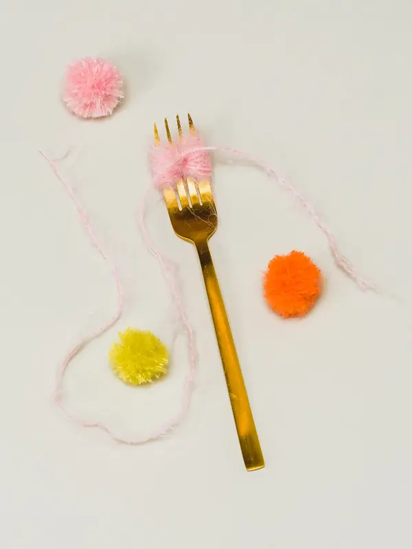 Tre dusker og en gullskje med tråd nøstet rundt