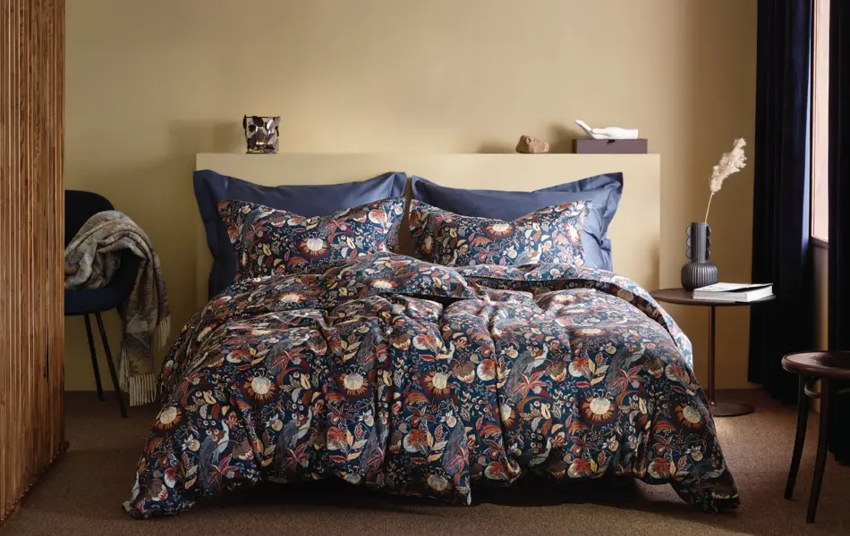 Seng med mønster sengesett og brune vegger