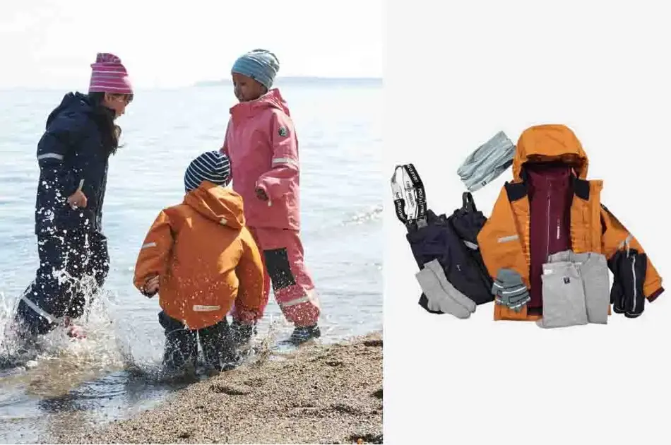 Tre barn som leker i vannkanten med regnklær