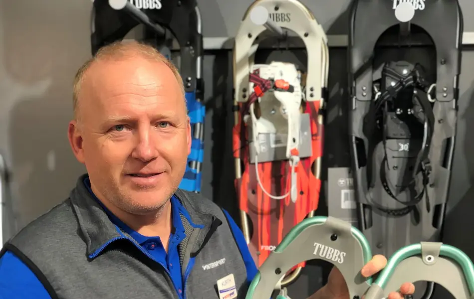 ansatt hos intersport viser frem utvalg av truger