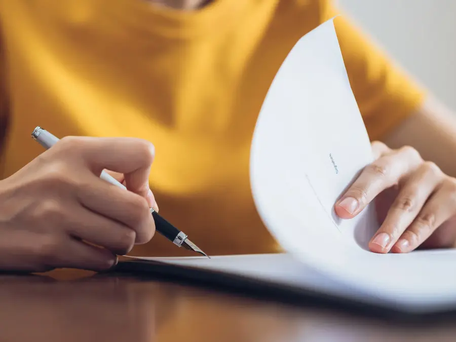 Woman signing document and hand holding pen putting signature at paper, order to authorize their rights.