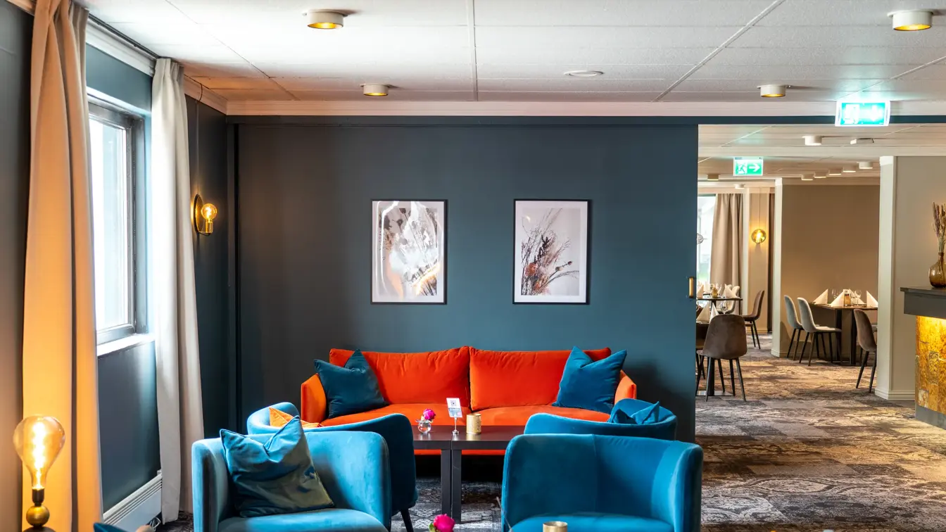 Blå lenestoler, grå sofa, peis, vindu, salongbord, rød sofa