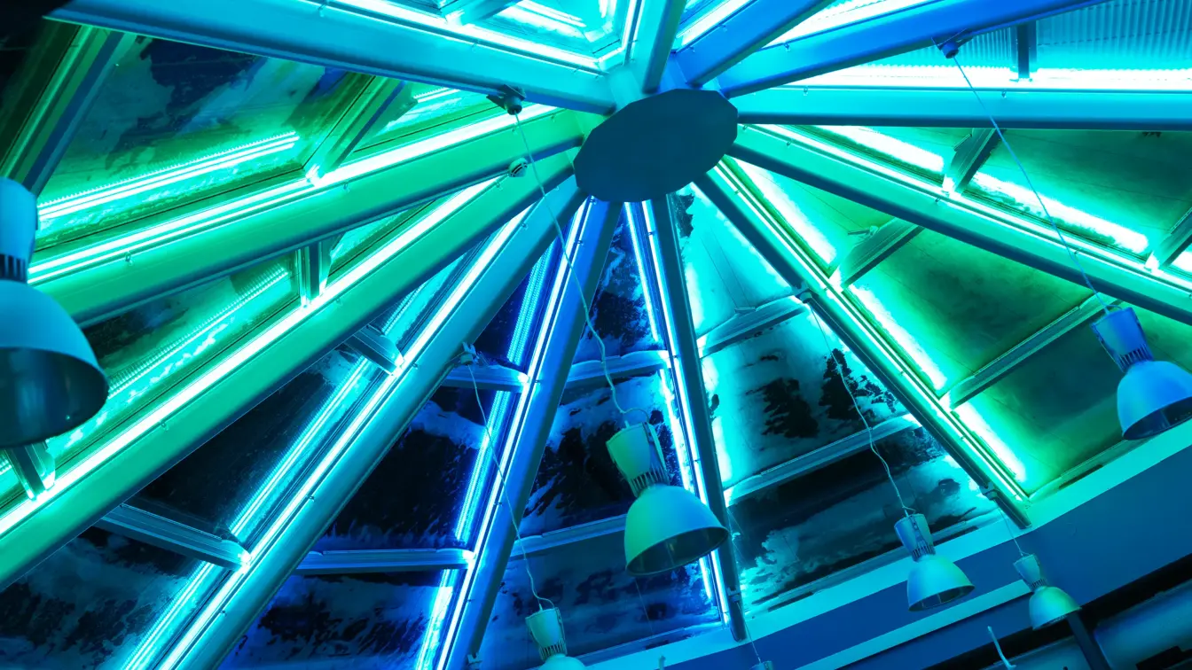 Nærbilde av takvinduet i kurs- og konferansesalen Varri på Thon Hotel Kautokeino. Vinduet i møterommet er opplyst i grønt og blått. 