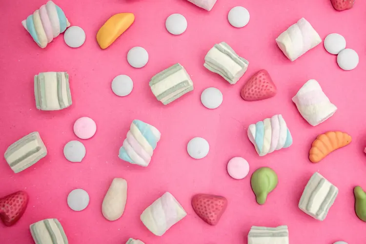 Godteri strødd omkring på rosa bakgrunn