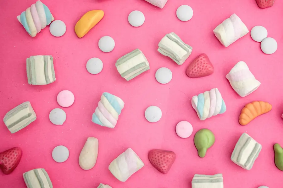Godteri strødd omkring på rosa bakgrunn