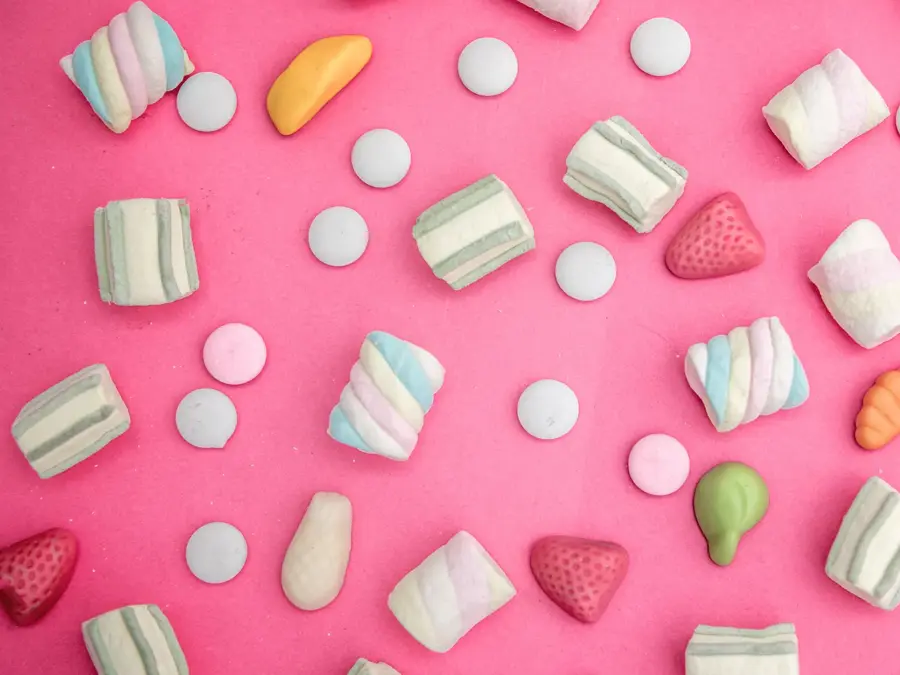 Godteri strødd omkring på rosa bakgrunn