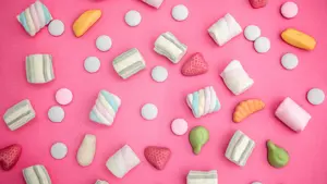 Godteri strødd omkring på rosa bakgrunn