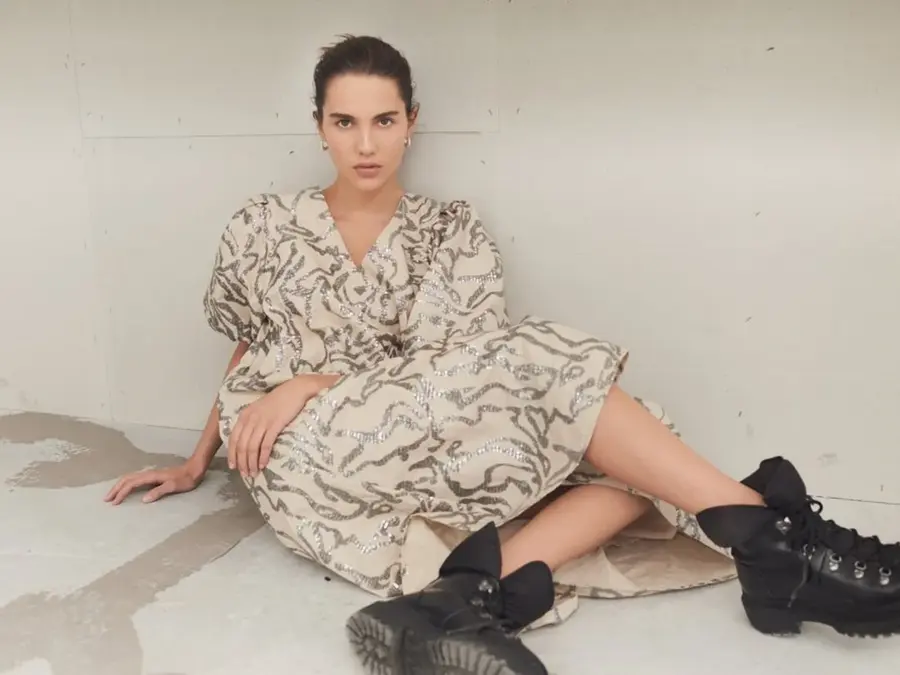 dame som sitter på gulvet med kjole og boots på