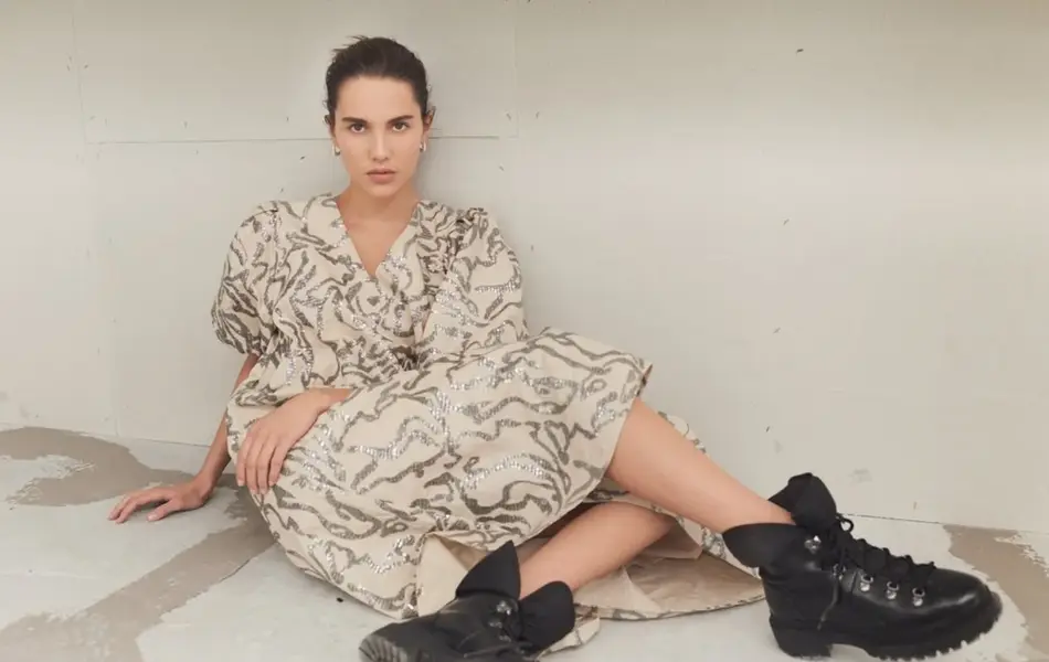 dame som sitter på gulvet med kjole og boots på