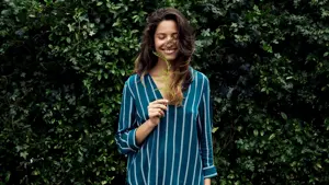 Dame holder plante og smiler 