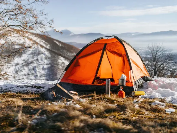 Oransje telt med leirplass i delvis snødekt landskap