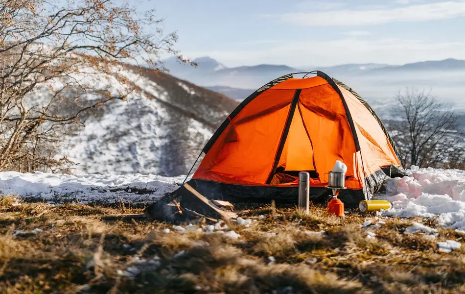 Oransje telt med leirplass i delvis snødekt landskap