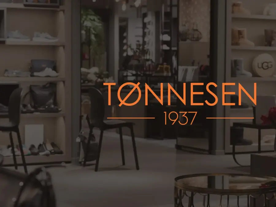 Bilde av en butikk i bakgrunnen, med logoen til Tønnesen 1937 på midten