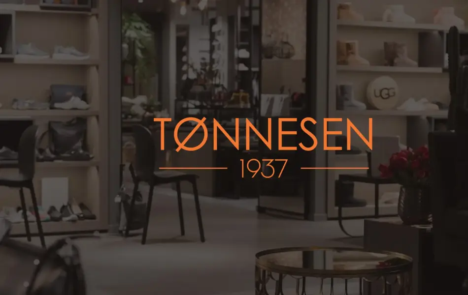 Bilde av en butikk i bakgrunnen, med logoen til Tønnesen 1937 på midten