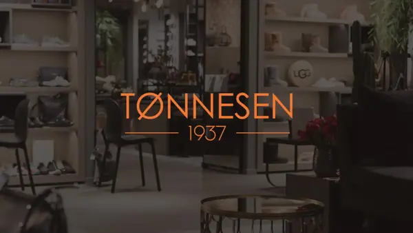 Bilde av en butikk i bakgrunnen, med logoen til Tønnesen 1937 på midten