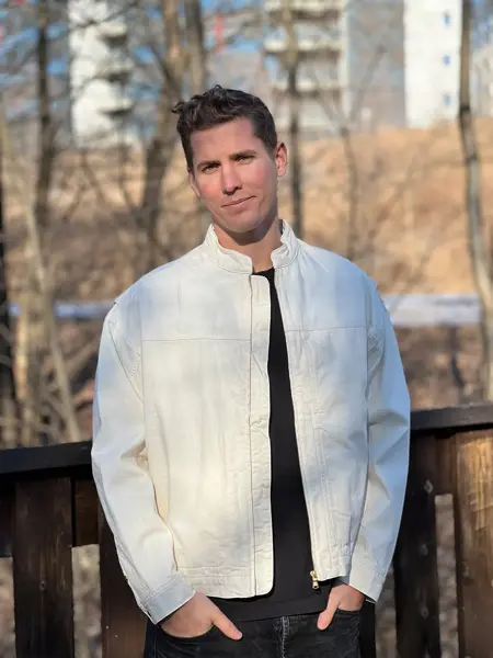 Mann med hvit jakke som smiler