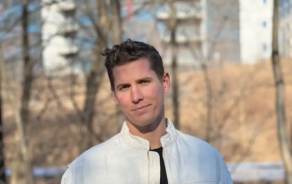 Mann med hvit jakke som smiler