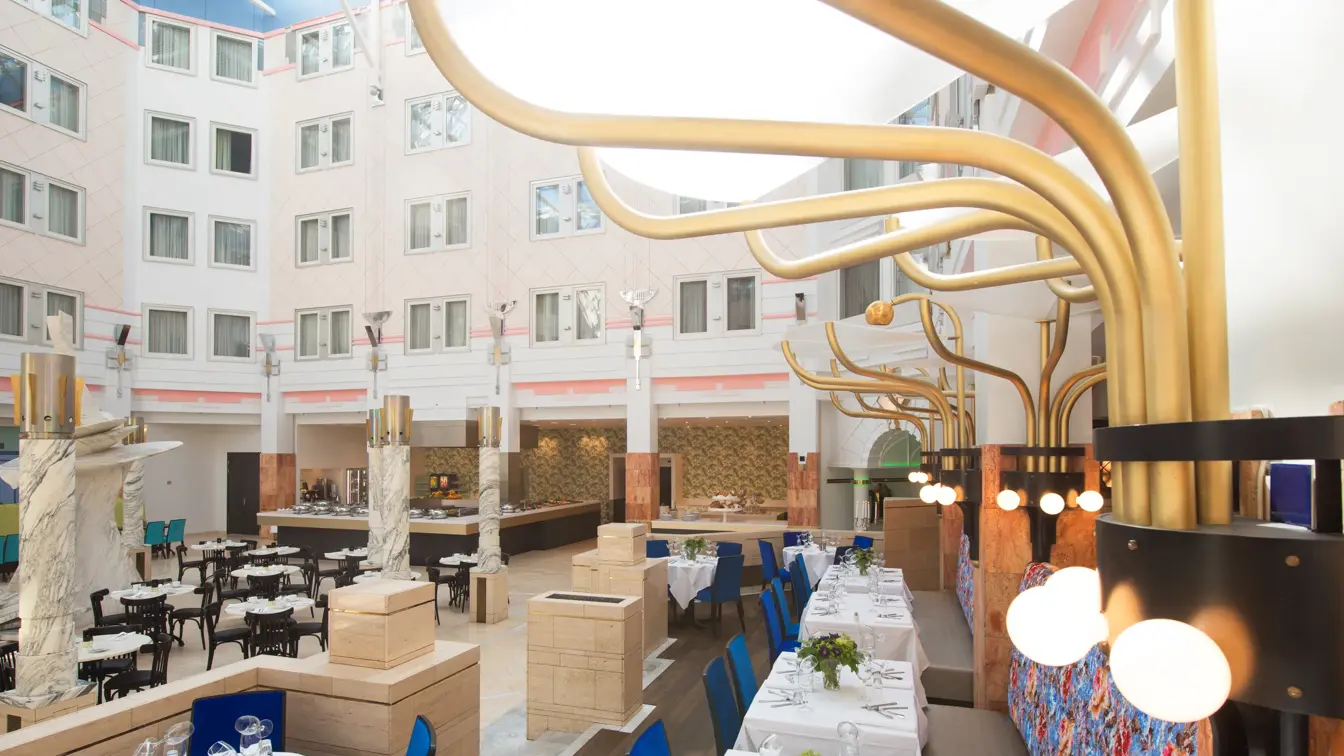 Dekkede bord med fargerike sitteplasser og runde store lamper på Restaurant Claude Monet på Thon Hotel Oslofjord i Sandvika