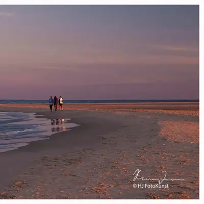 3 personer som går på en strand