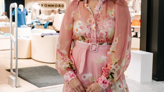 dame i kjole står foran butikk