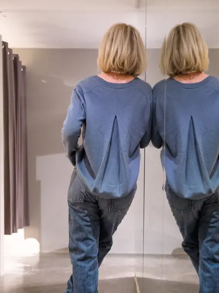 ryggen til dame med dueblå cardigan med legg-detalj på ryggen